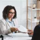 A woman giving her resume to the recruitment director in hopes to secure a position